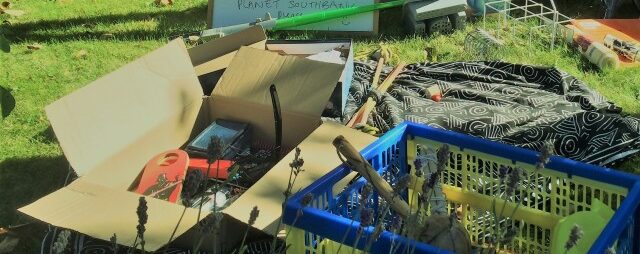 Boxes of household items lie on the floor in front of a sign saying 'Southbank street recycle'