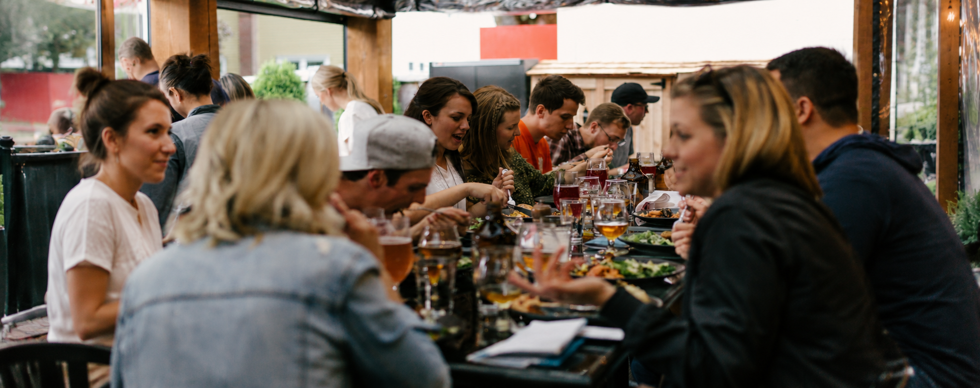 A group of people sitting around a table, eating a meal.